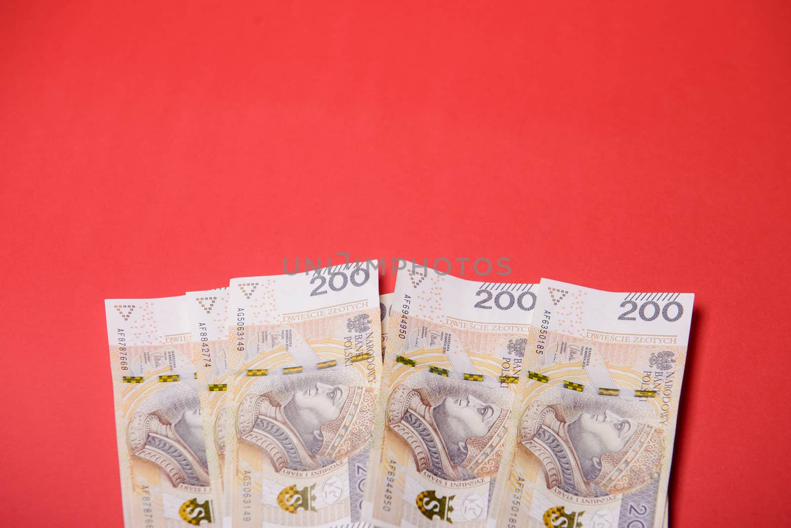 Polish zloty in notes and coins on red background