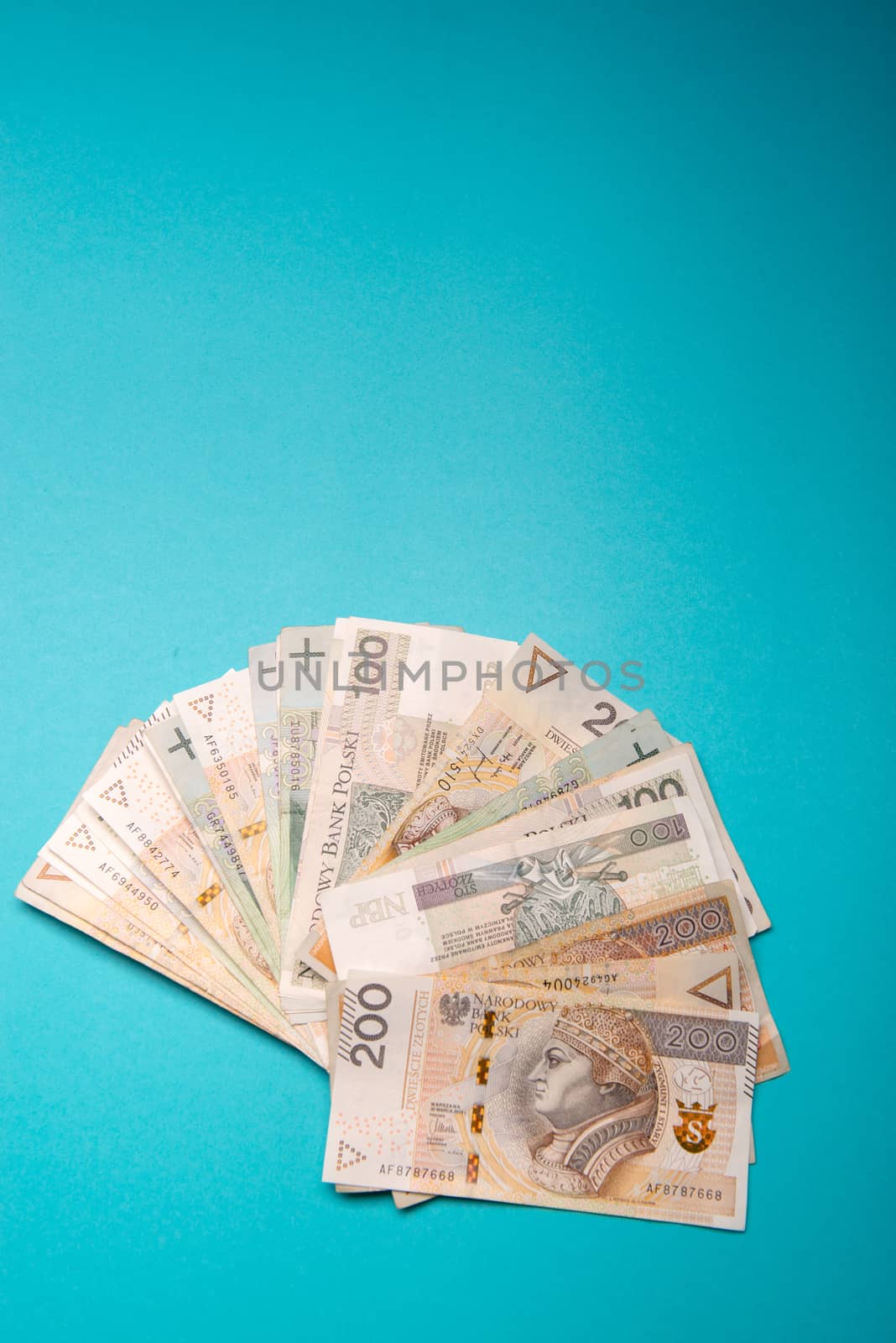 Polish zloty in notes and coins on blue background