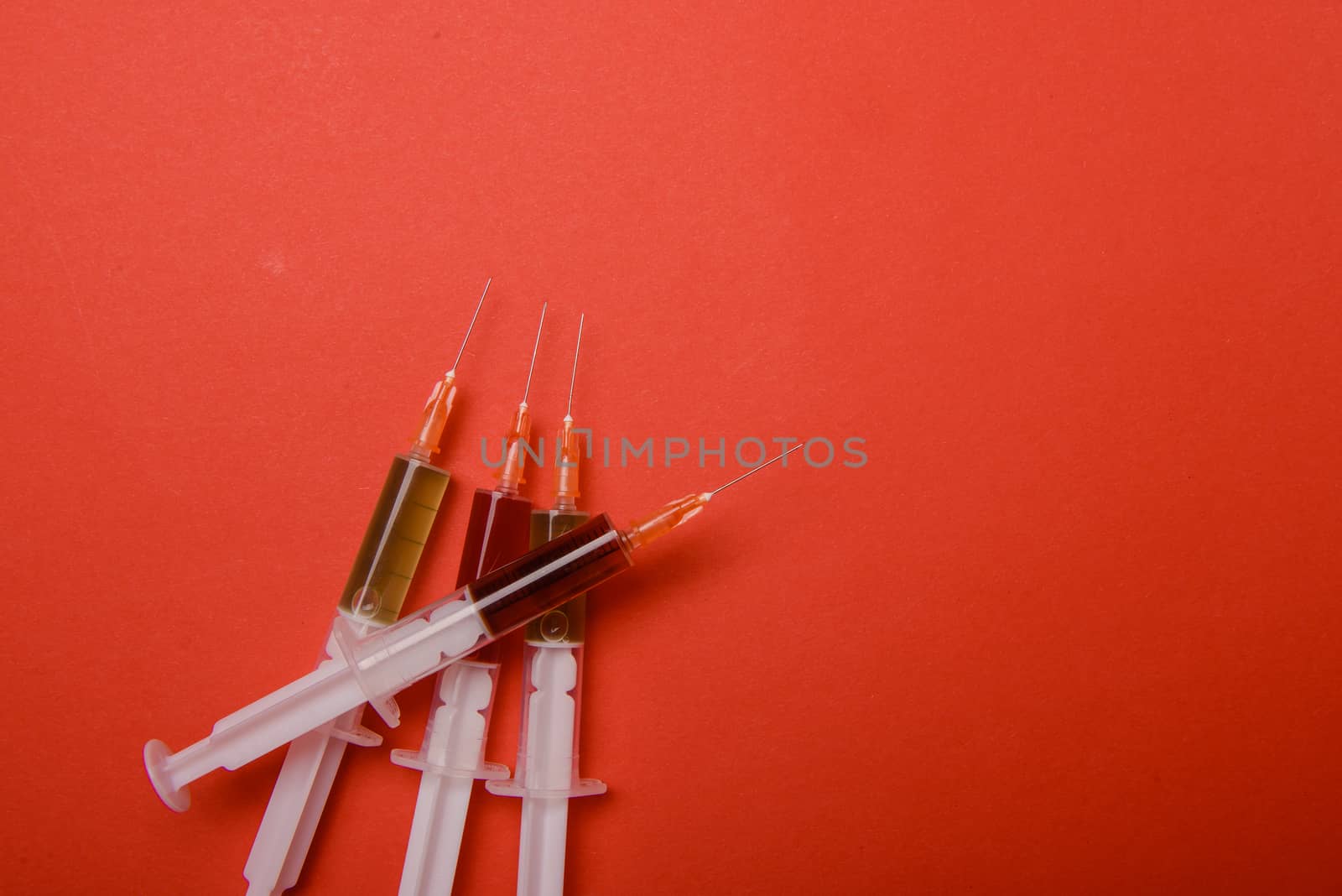 Hand in glove with syringe on red background. Injections.