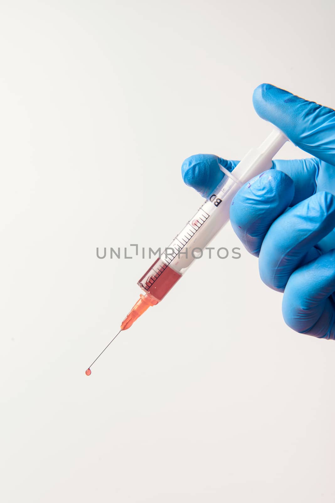 Hand in glove with syringe on white background. Injections.