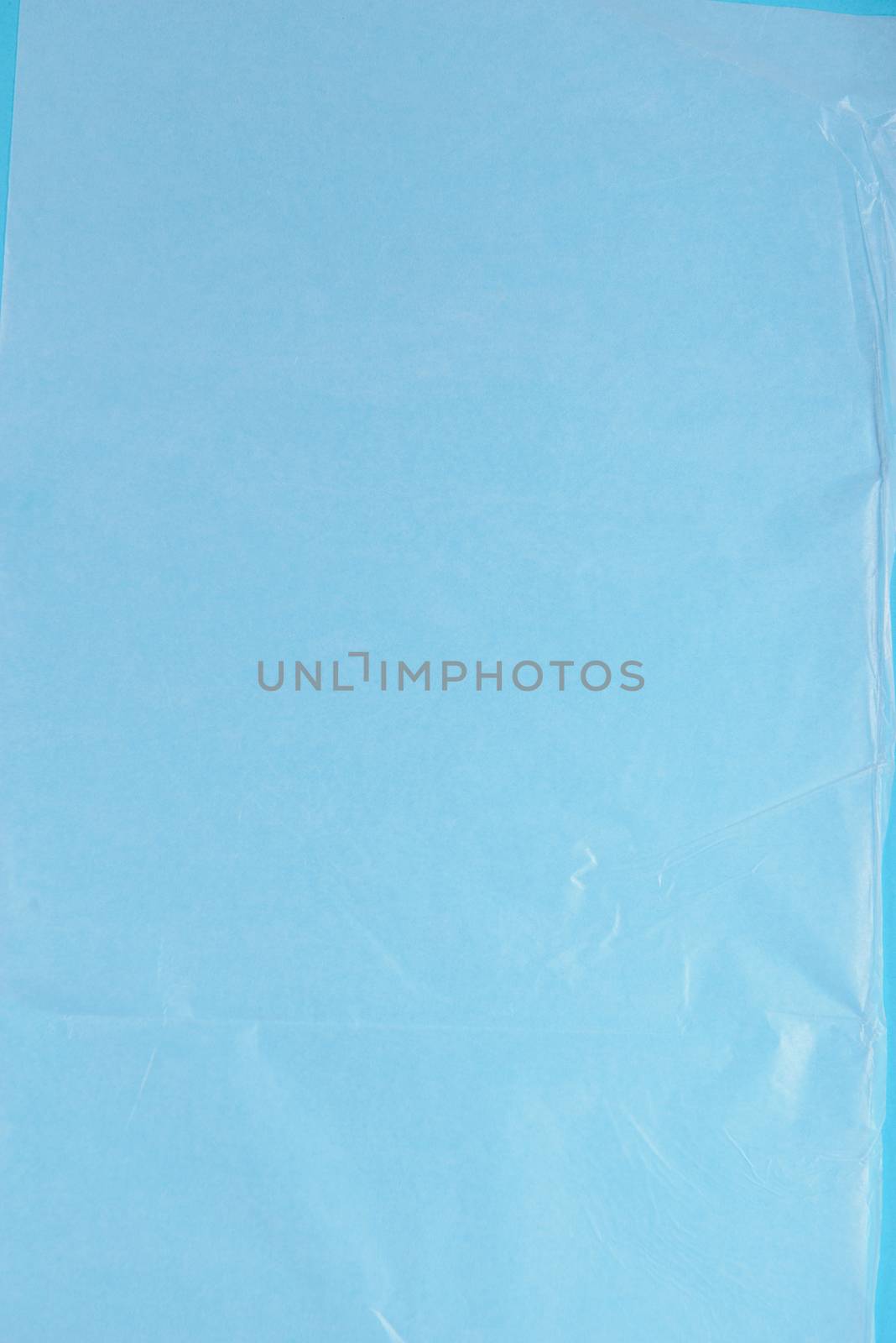 Plastic wrap on blue background, high resolution