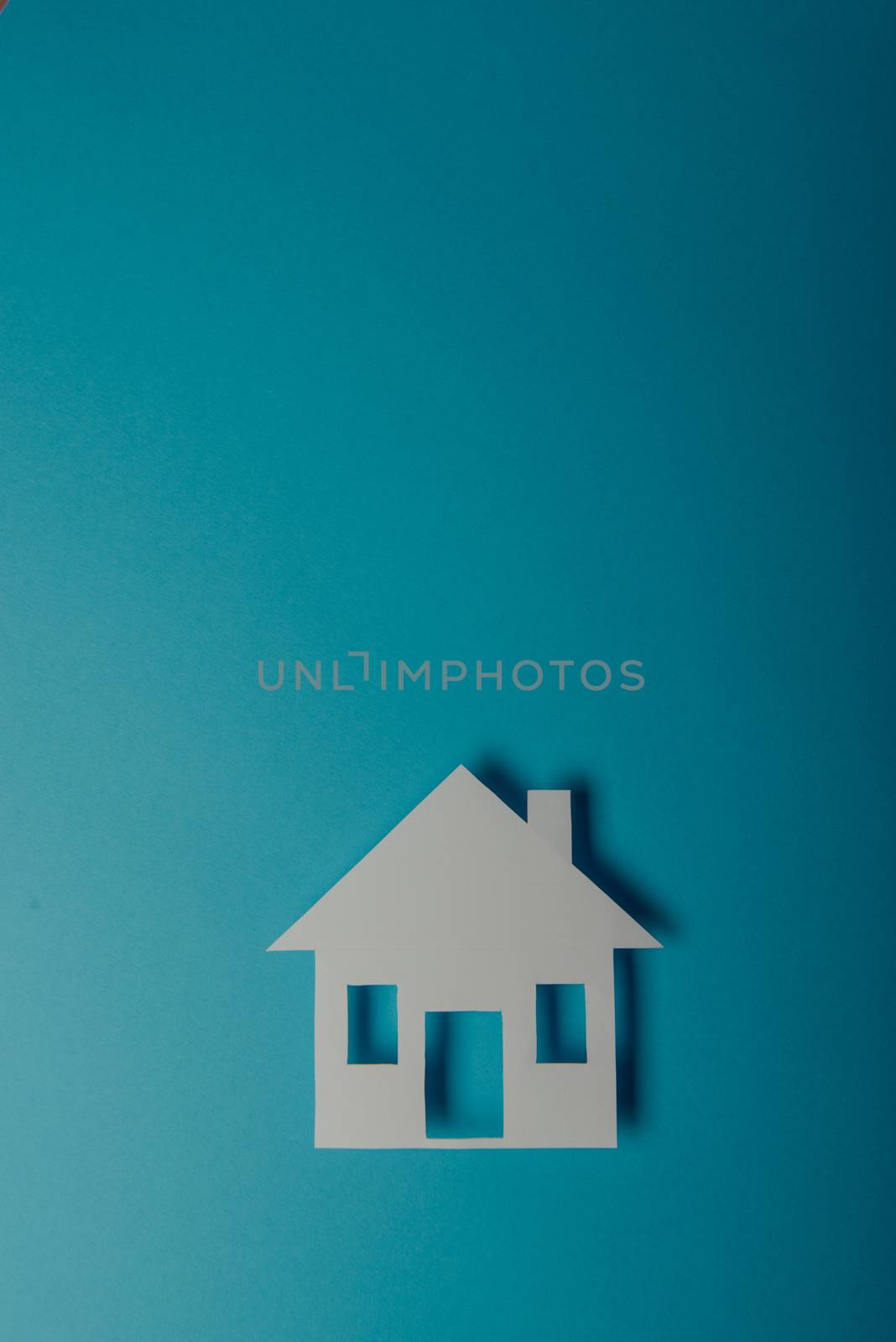 House shaped paper cutout on on blue background