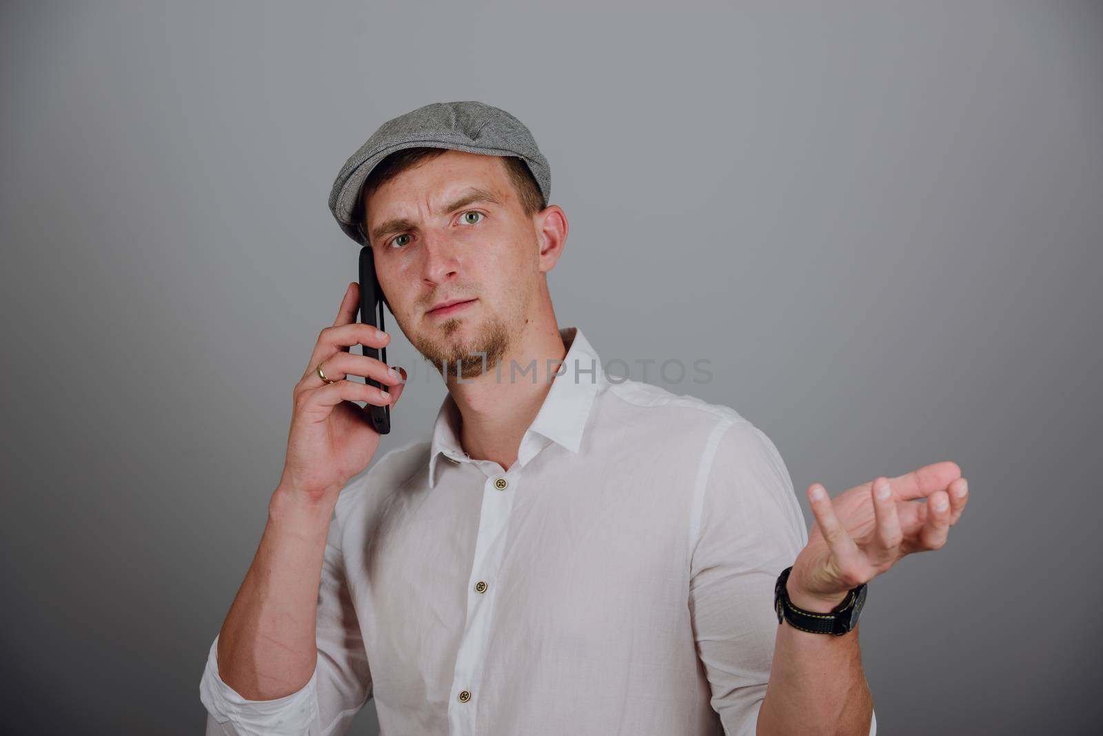 Portrait Of Happy Young Man Talking On Cell Phone Isolated On gray Background