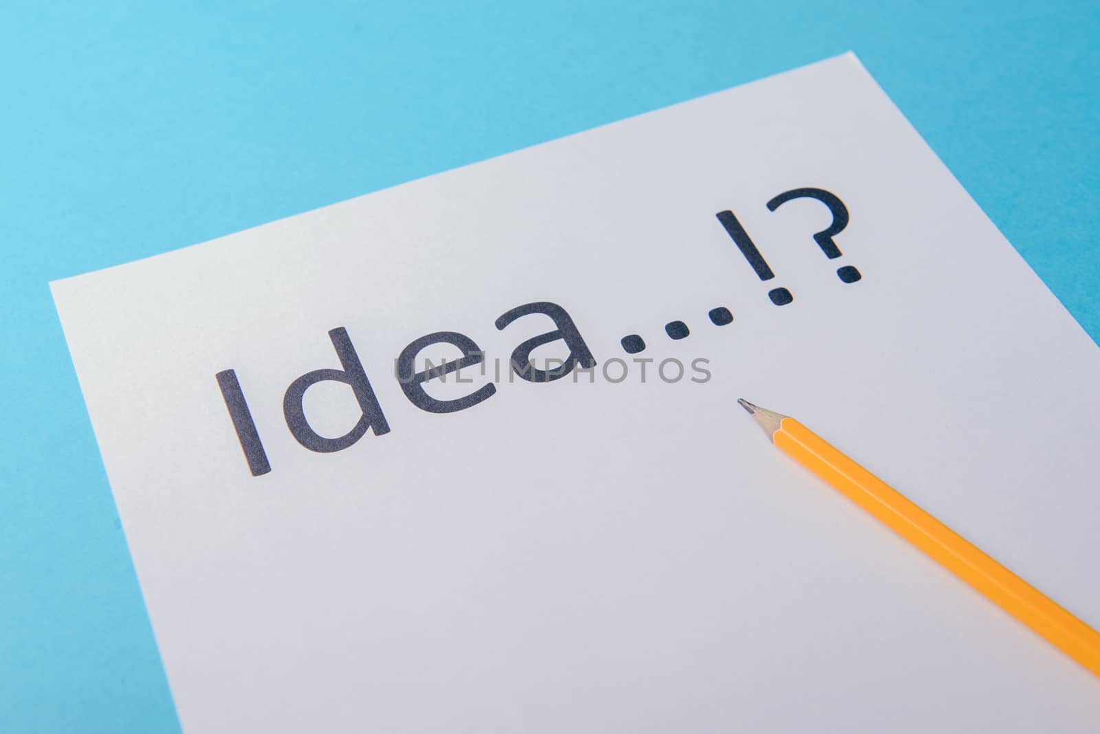 Idea word on white paper with pen. Blue background
