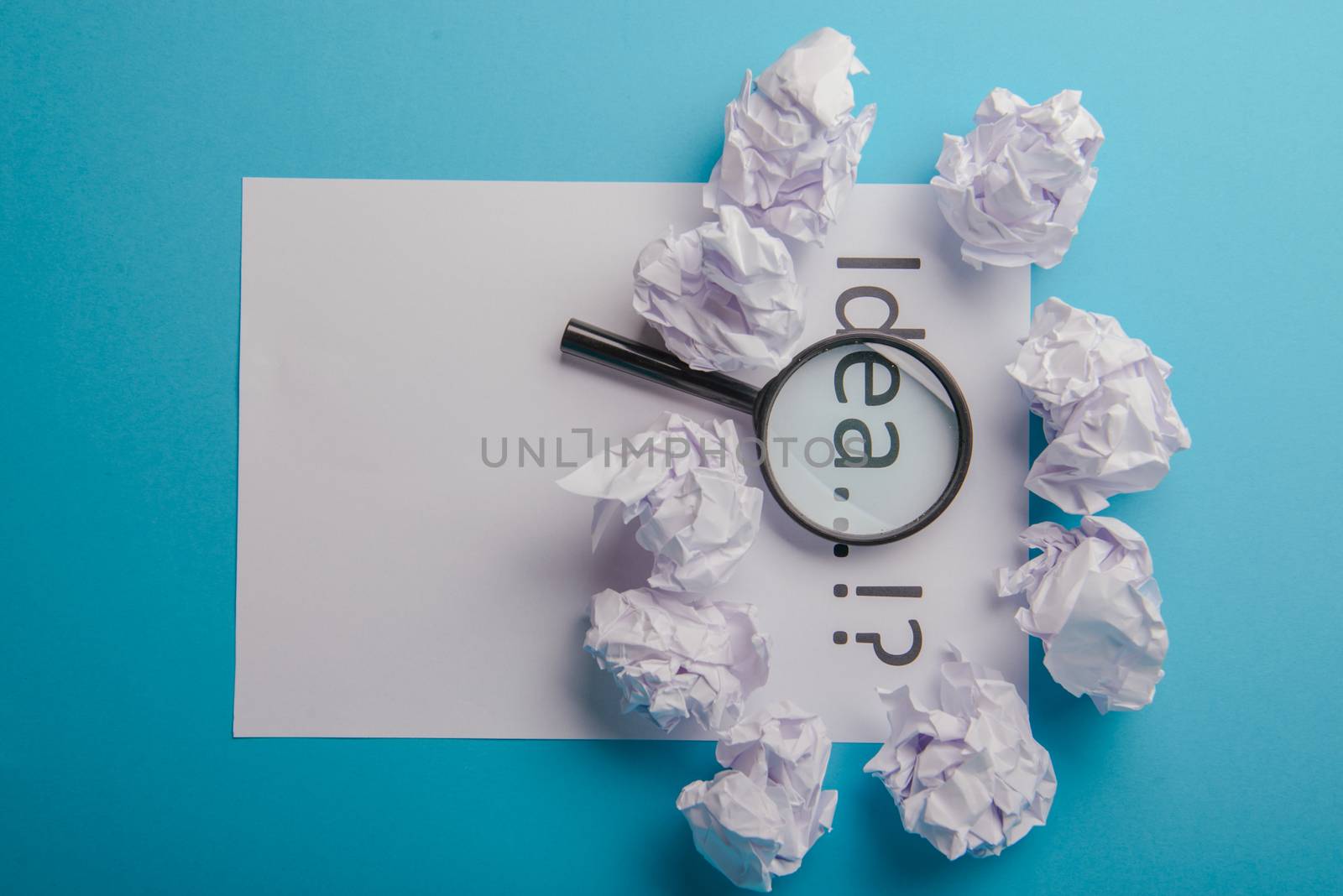 Idea word written on white paper. Blue background