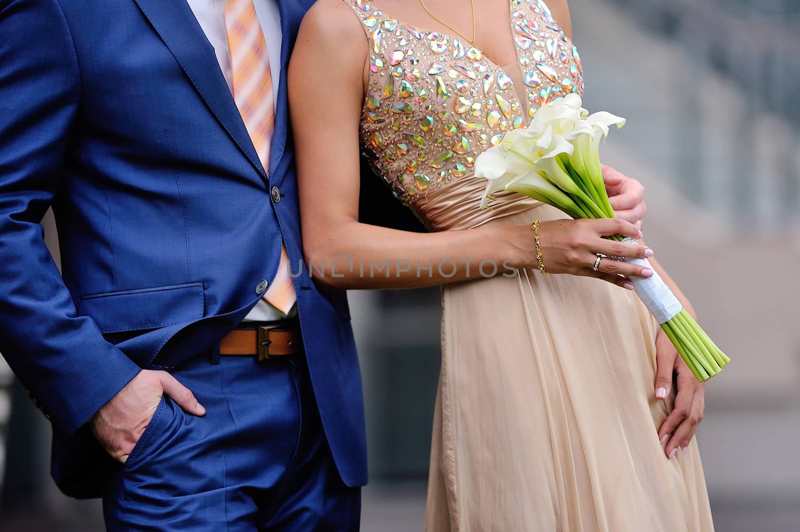 The groom embraces the bride 