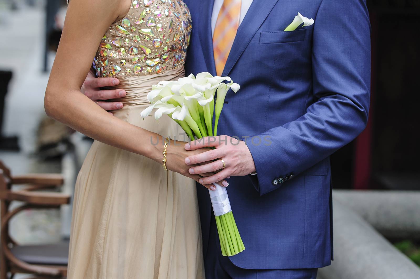 bride and groom holding a wedding bouquet of callas 