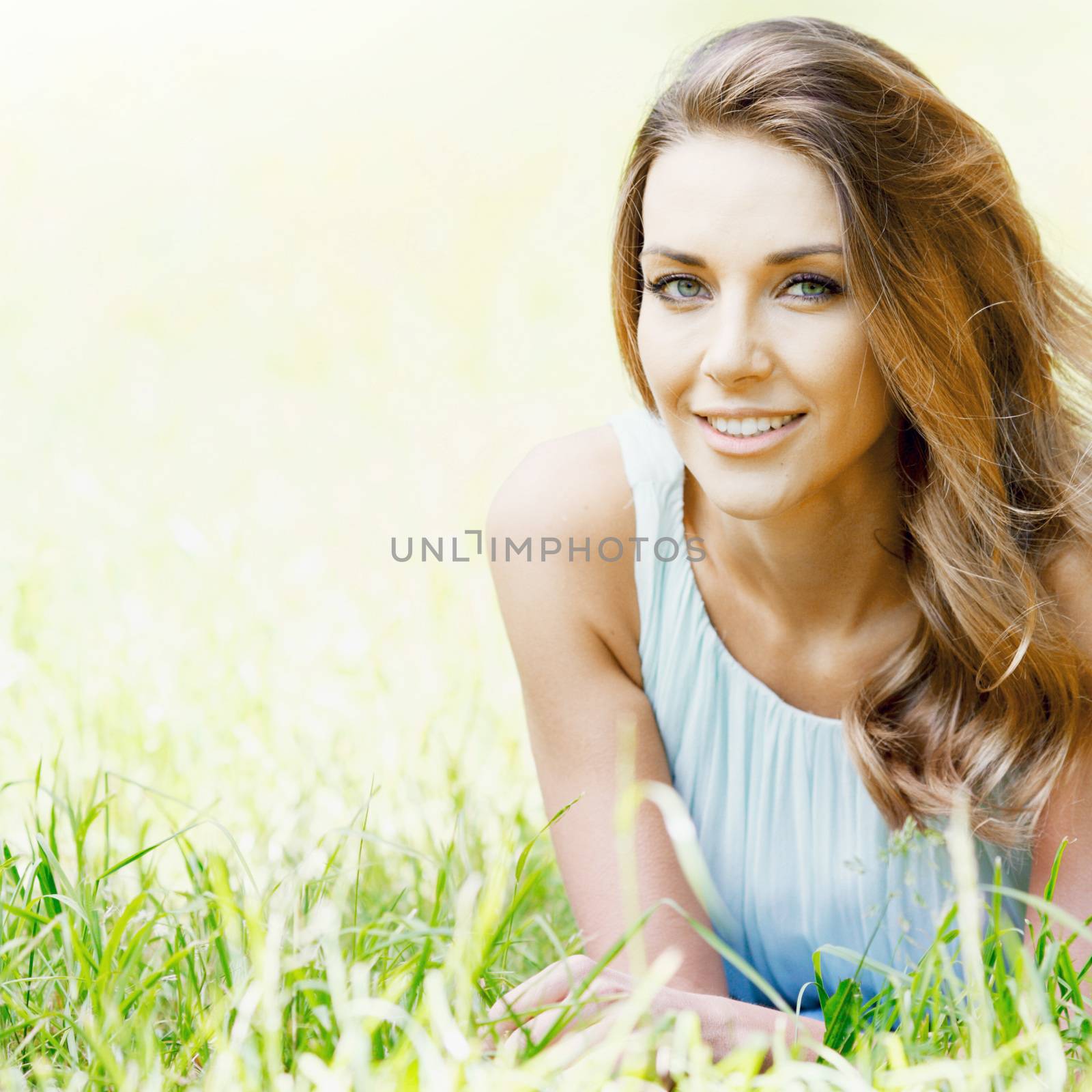 young woman in blue dress lying on grass by Yellowj