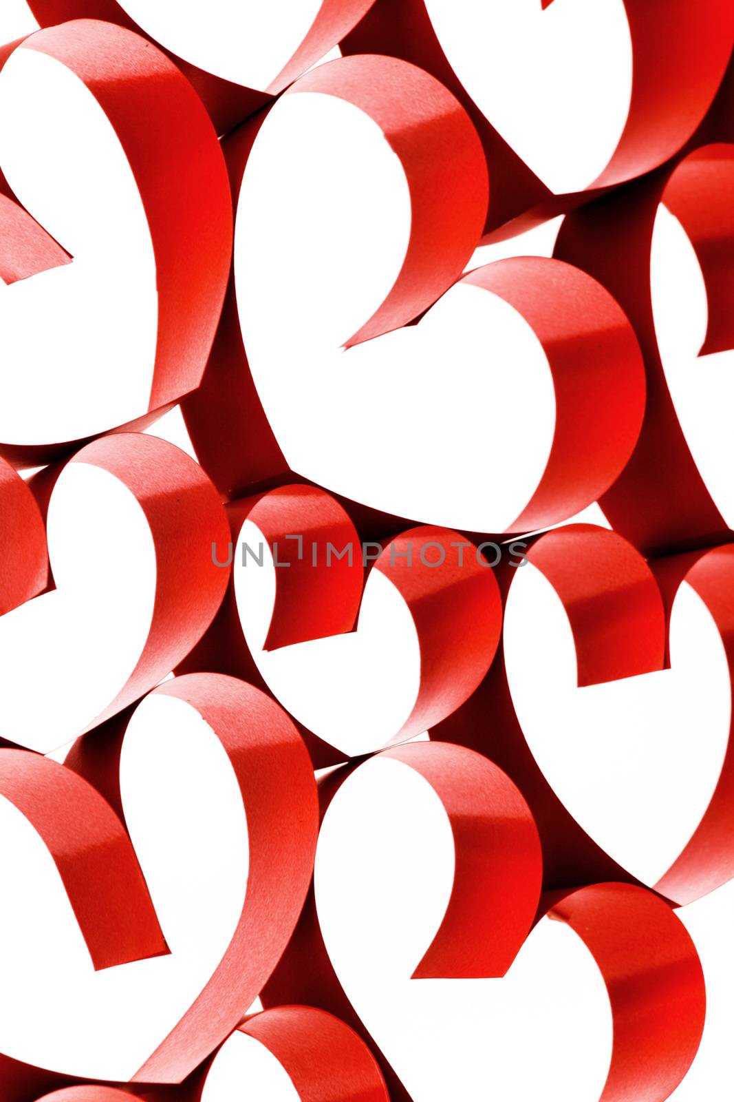 Red ribbons shaped as hearts on white background