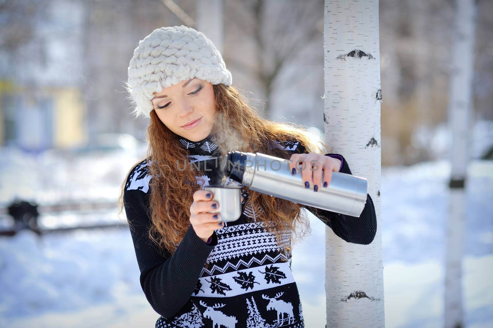 beautiful girl with thermos and cup hot tea in frosty winter day by timonko