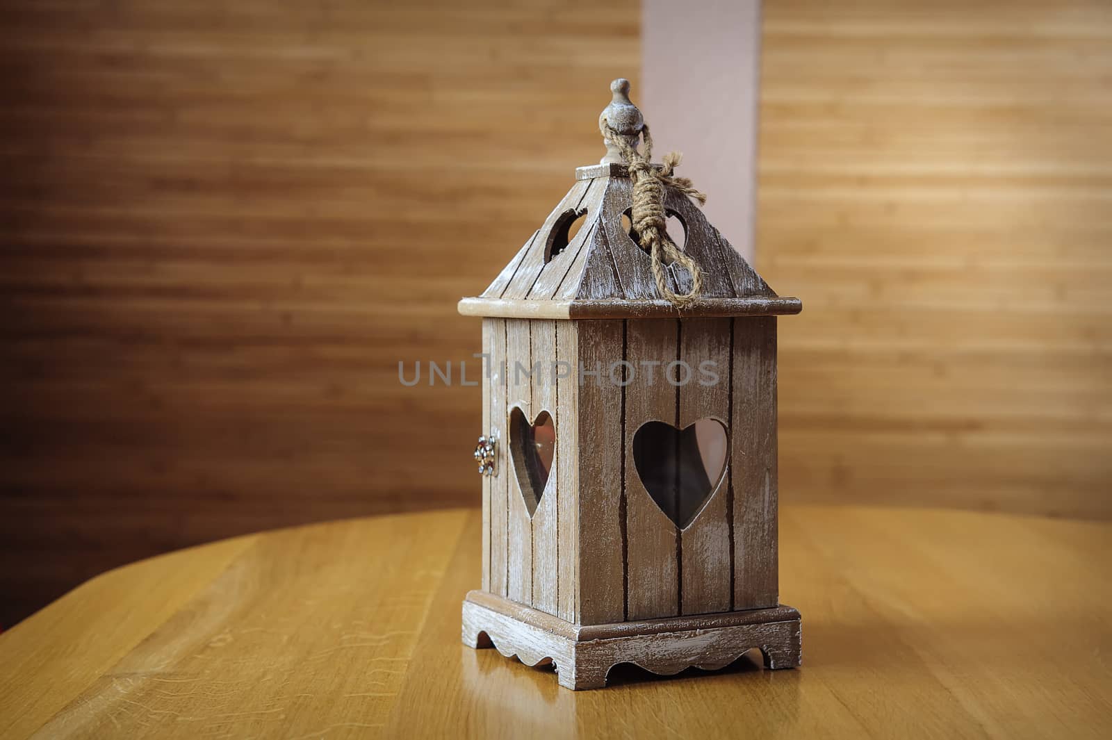 White lantern with flowers on wooden table, close-up 