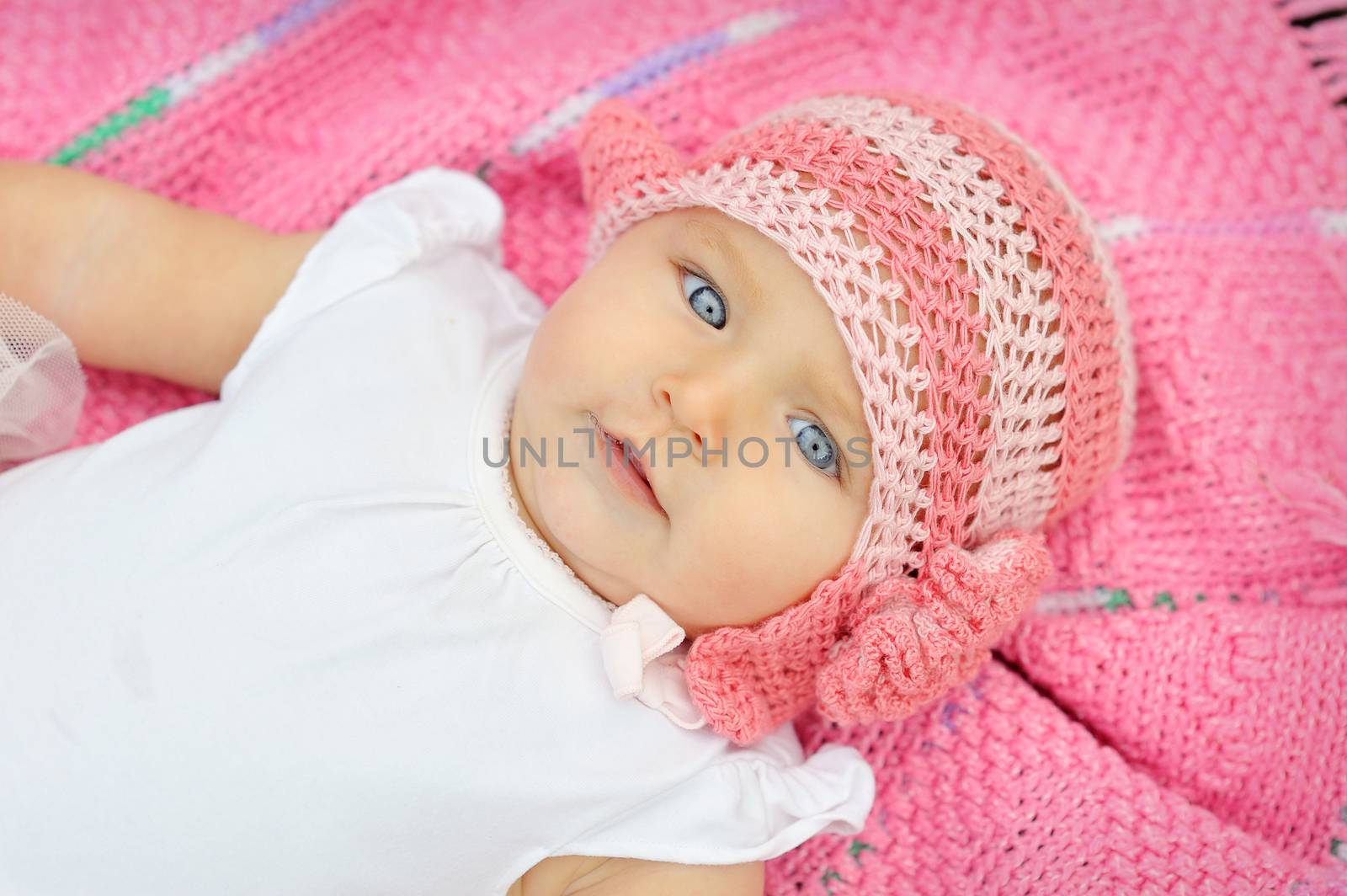 A baby in a pink knitted hat