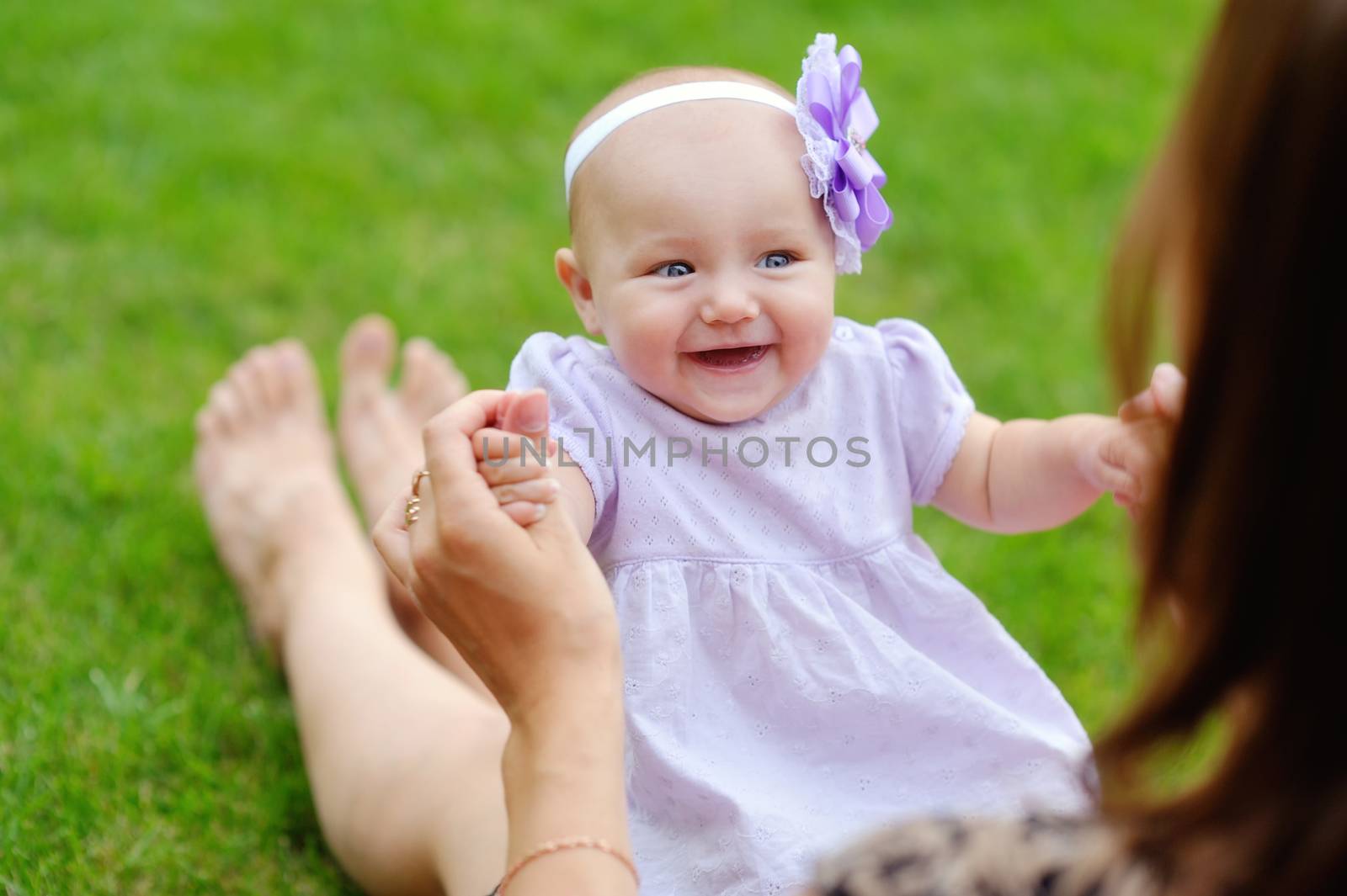 mother holding cute infant in hands. small baby lying in parent hands 