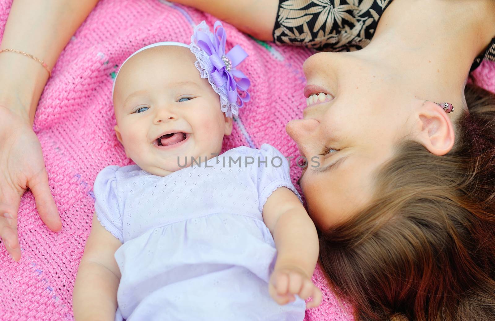 Beautiful Mother And Baby outdoors. Nature. Beauty Mum and her Child playing in Park together. Outdoor Portrait of happy family. Joy. Mom and Baby 