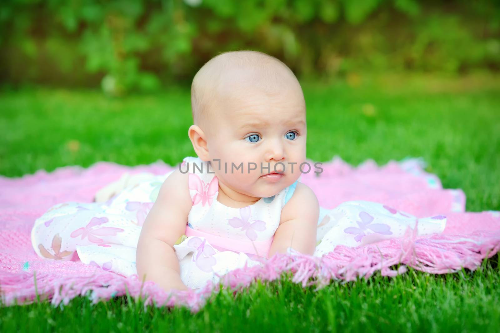 baby smiling and looking up to camera outdoors in sunlight  by timonko