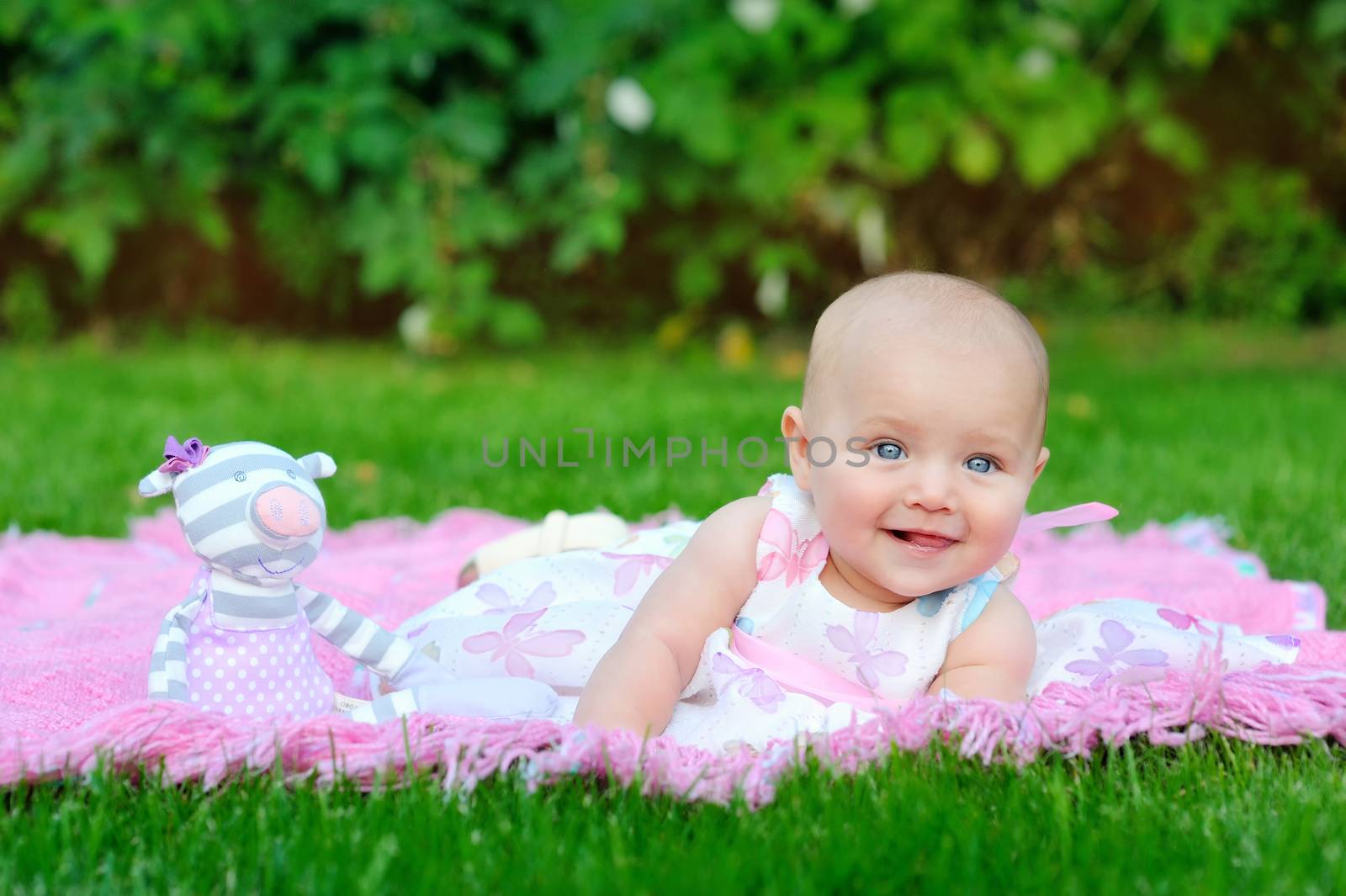 child, childhood and toddler concept - smiling baby lying on blanket and looking up 