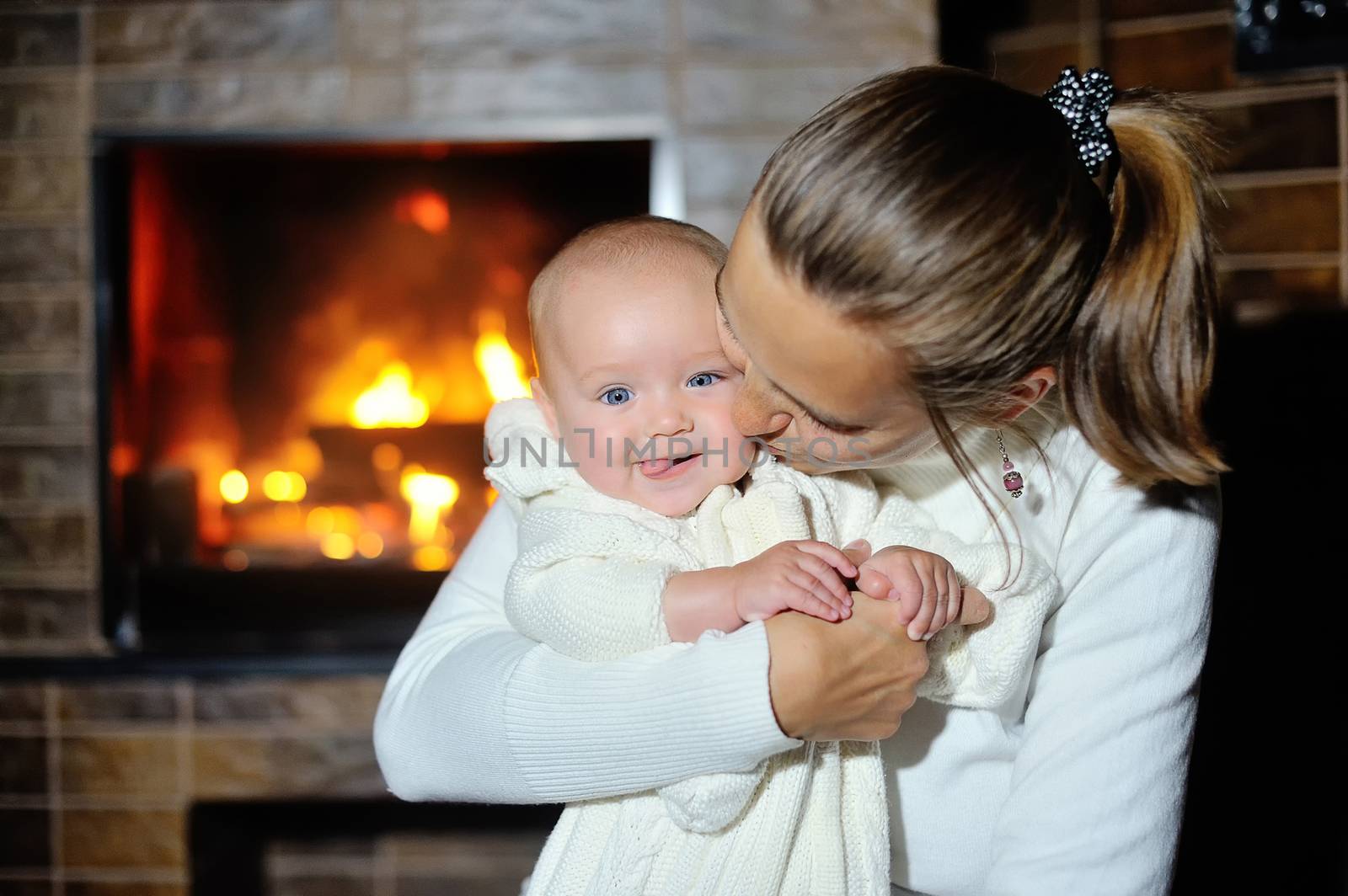 mother with her baby near the fireplace at home