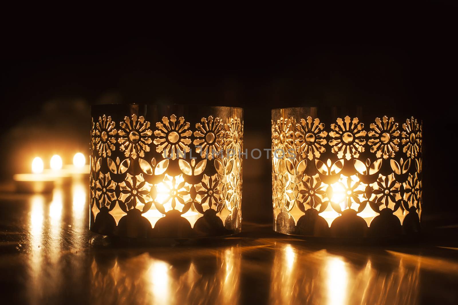 Two small burning candles on dark background 