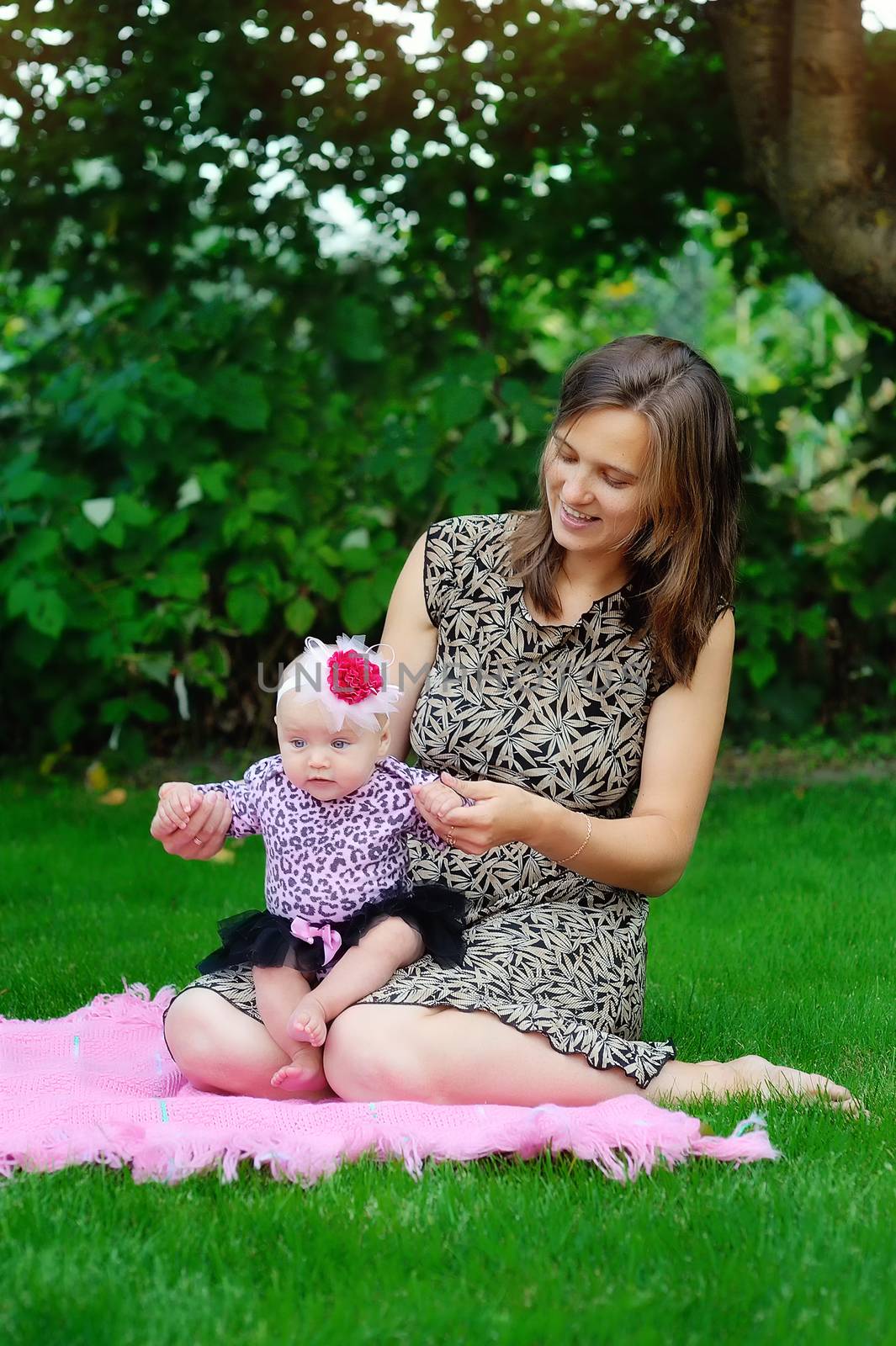 family, child and parenthood concept - happy mother holding and raising little baby up in park 