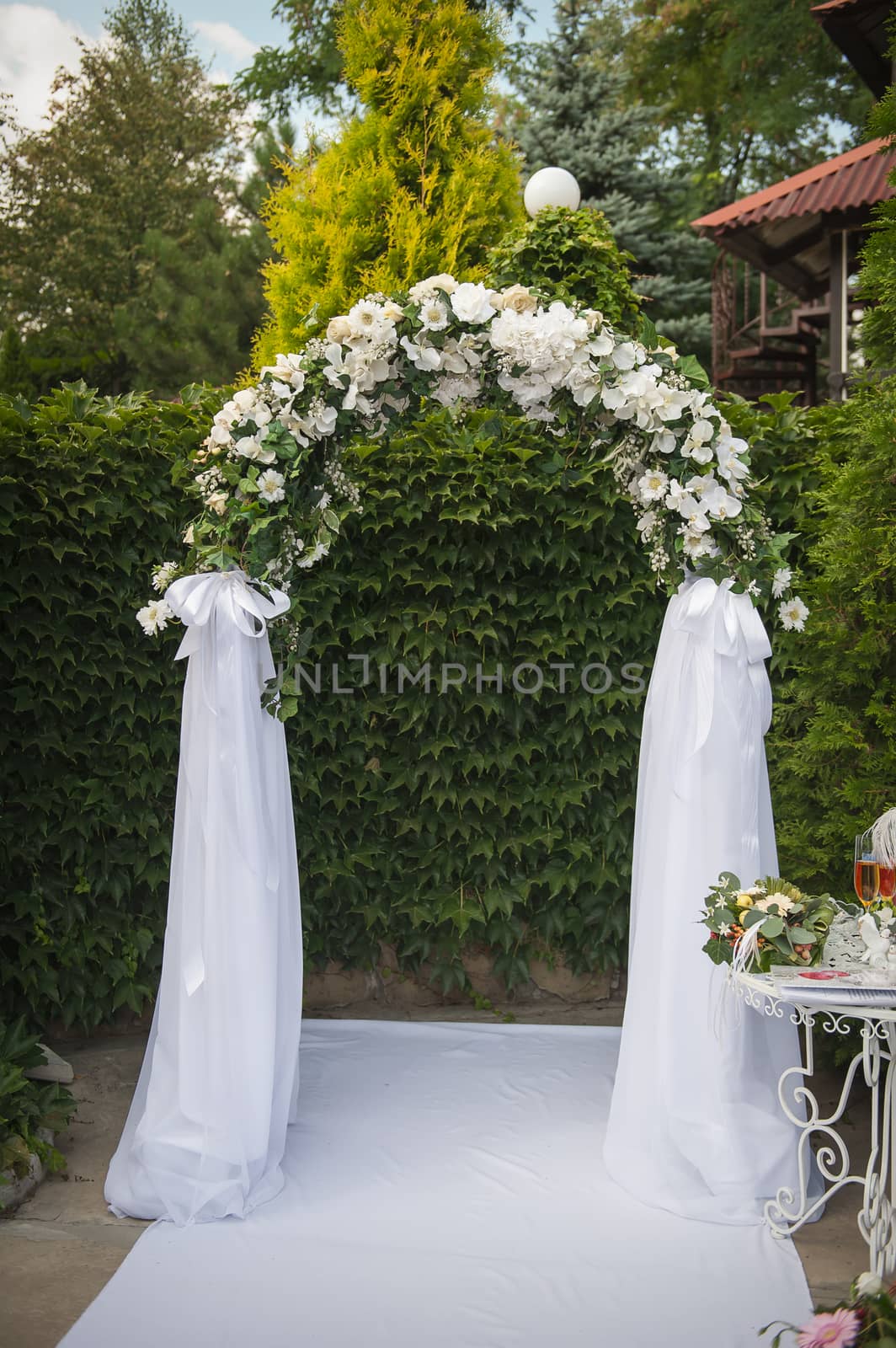 Arch and two white chairs in golf club prepared for weeding. Donetsk, Ukraine