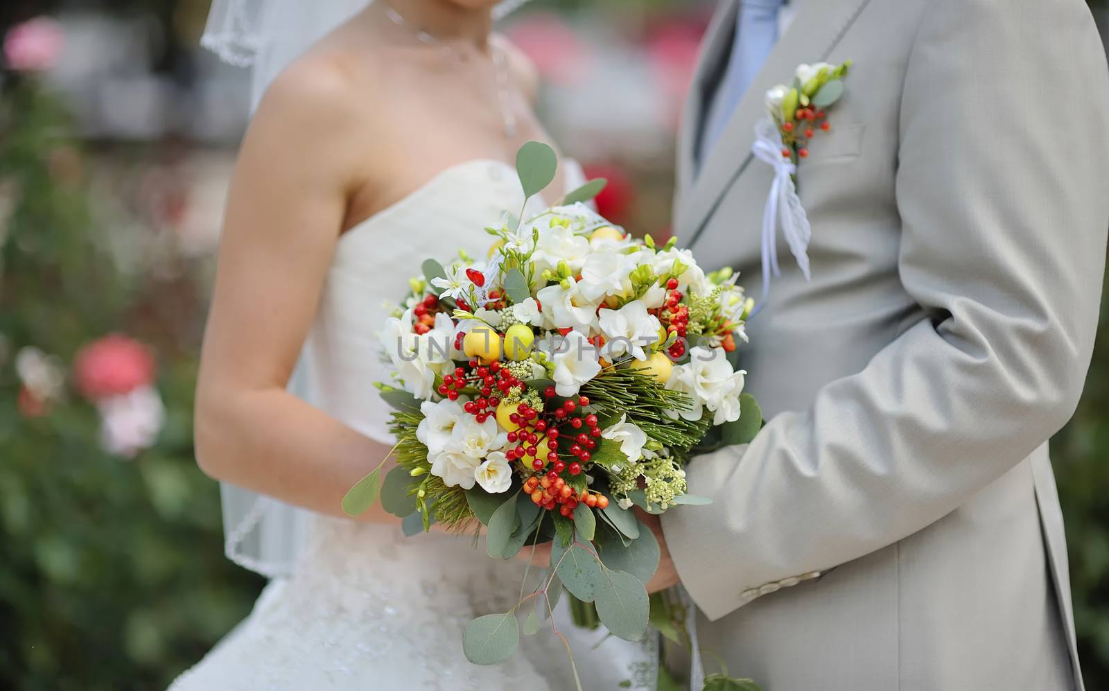 Bride holding wedding flower bouquet of white roses 