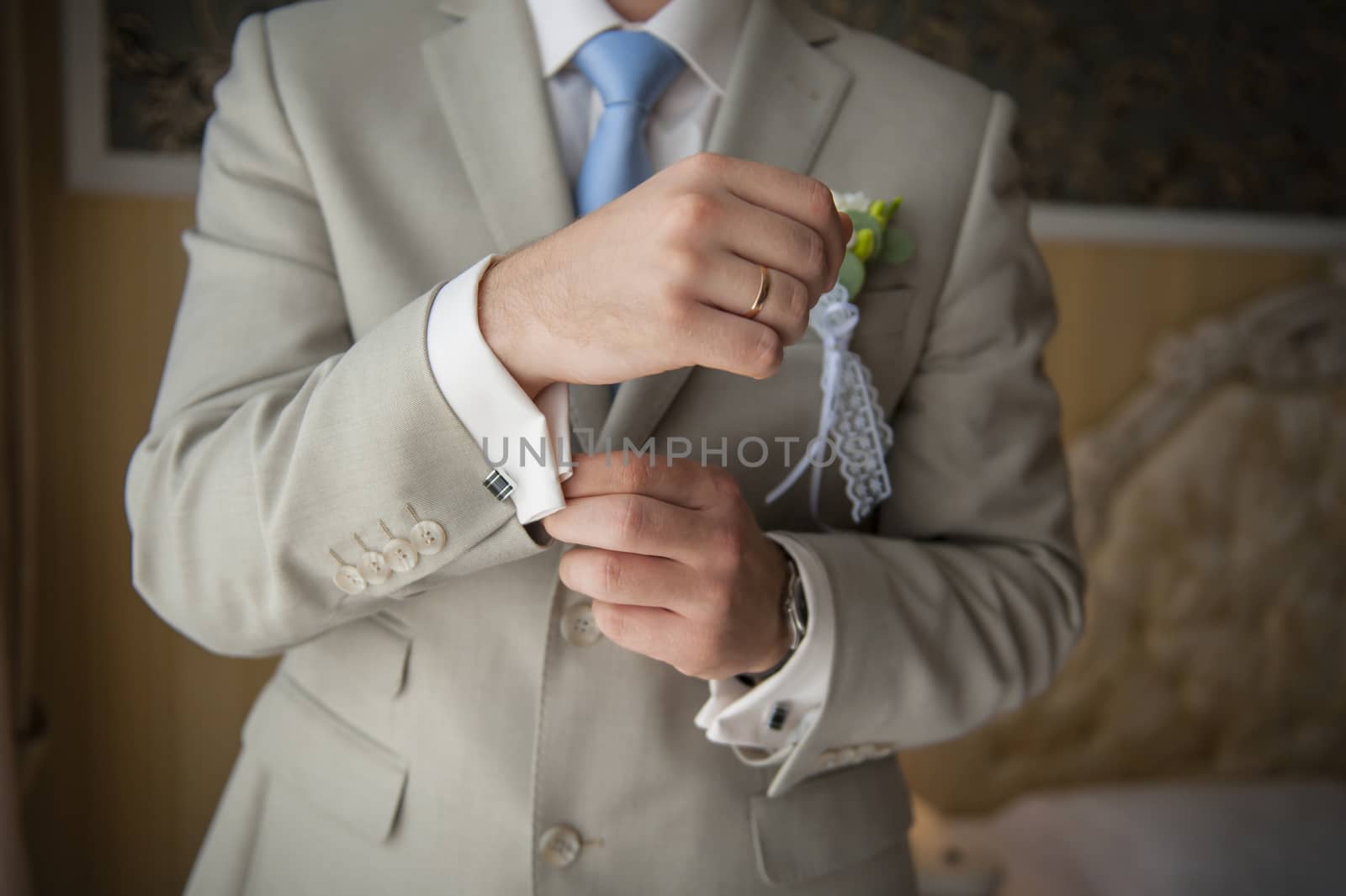 Hands of wedding groom getting ready in suit. 