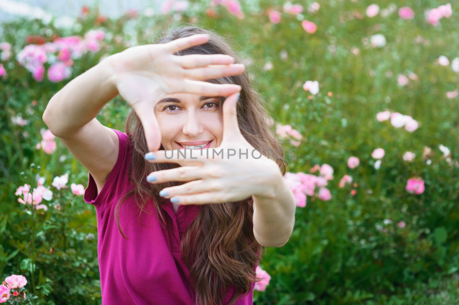 beautiful woman looks into the camera through fingers.