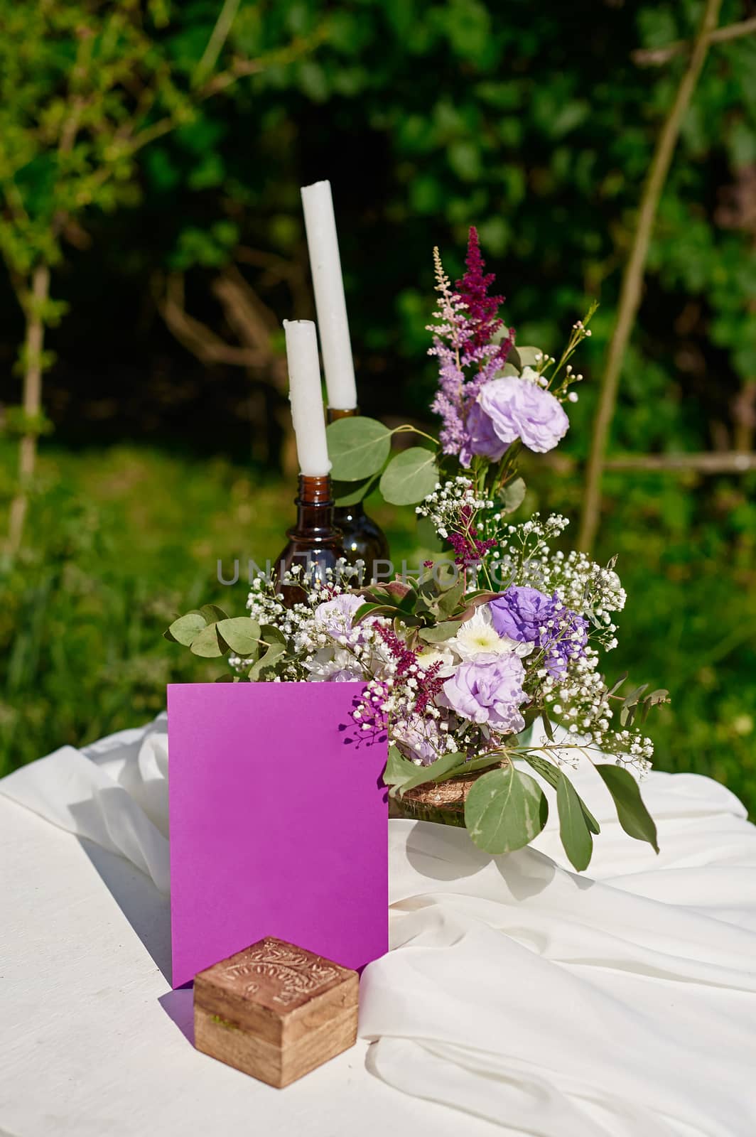 bouquet of flowers and two candles on the table for a wedding ceremony in the Park.