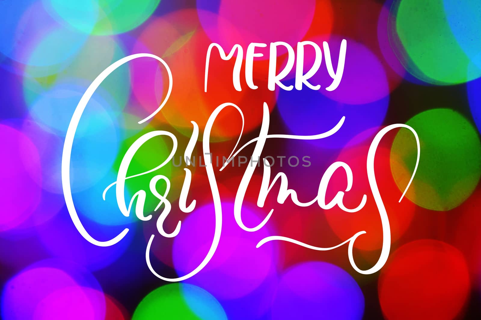 Colorful bokeh background for greeting or christmas card with words Merry Christmas. Calligraphy lettering