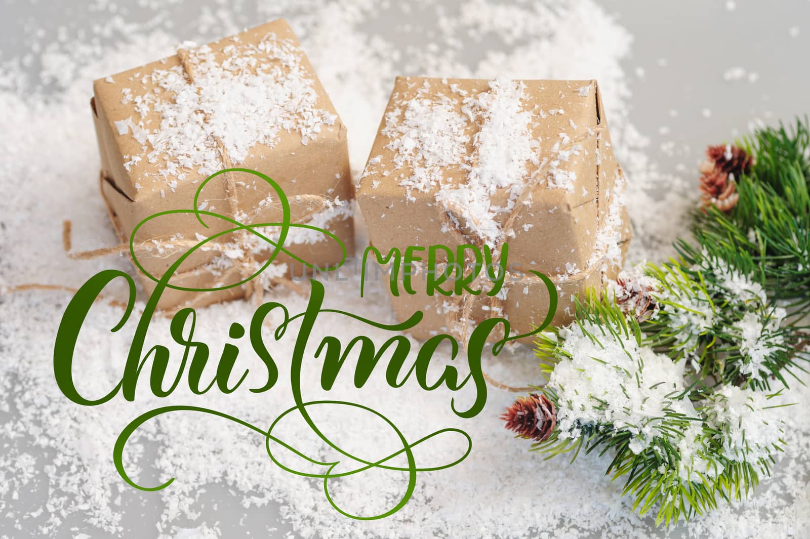 gift boxes of kraft paper with spruce branches and text Merry Christmas. Calligraphy lettering.