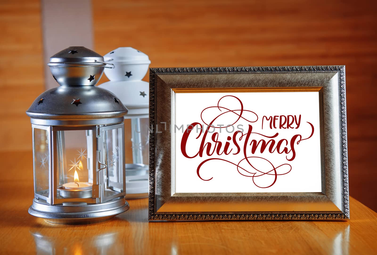 frame on the wooden table with text Merry Christmas. Calligraphy lettering.