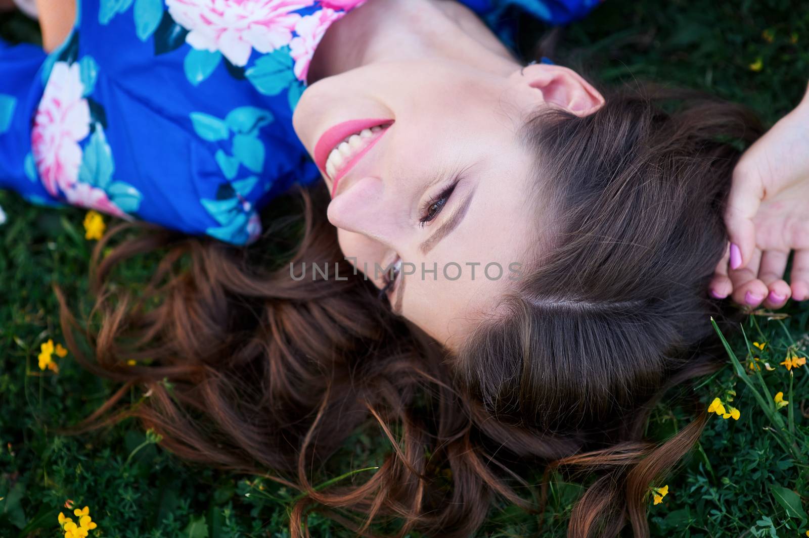 happy young woman lying on green grass.