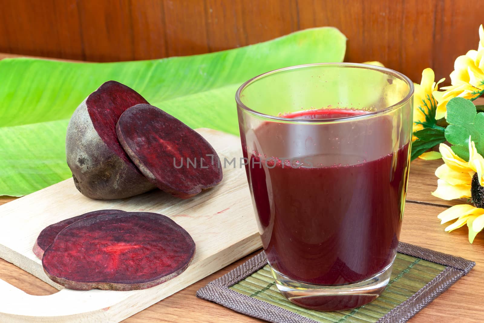 Fresh slices red beetroot and beetroot fruit juice in glass a wood background