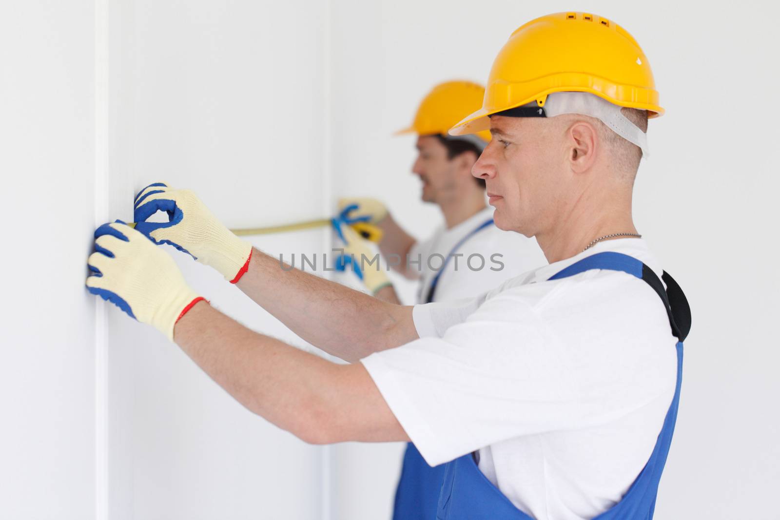 Building teamwork concept - group of smiling builders in hardhats with tools indoors