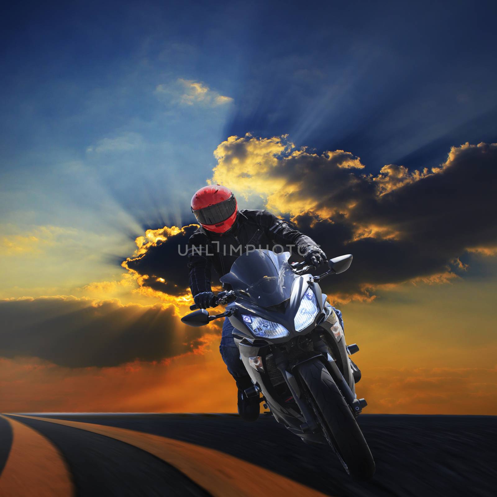 young man riding racing motorcycle on asphalt highway against beautiful dusky sky background use for biker traveling and journey theme