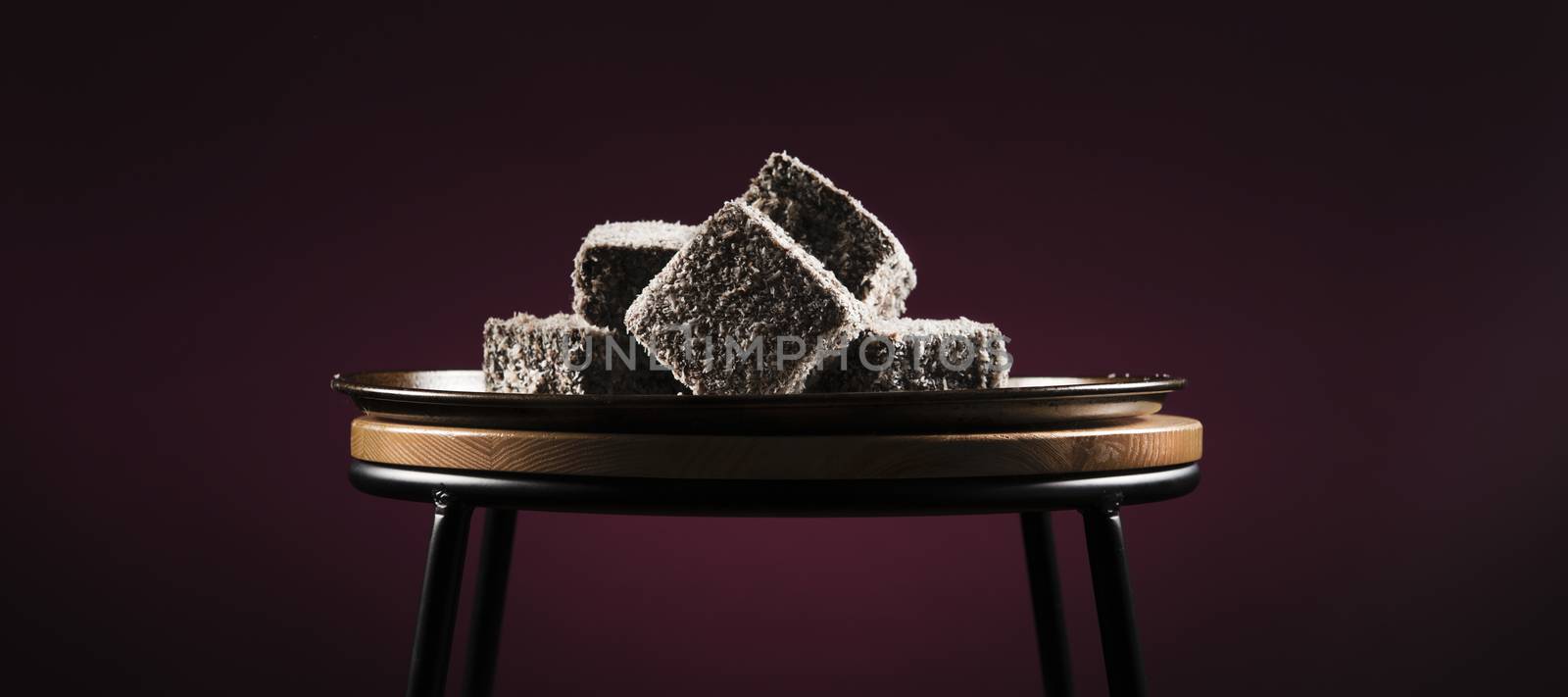 Group of Lamingtons on a metal baking tray.