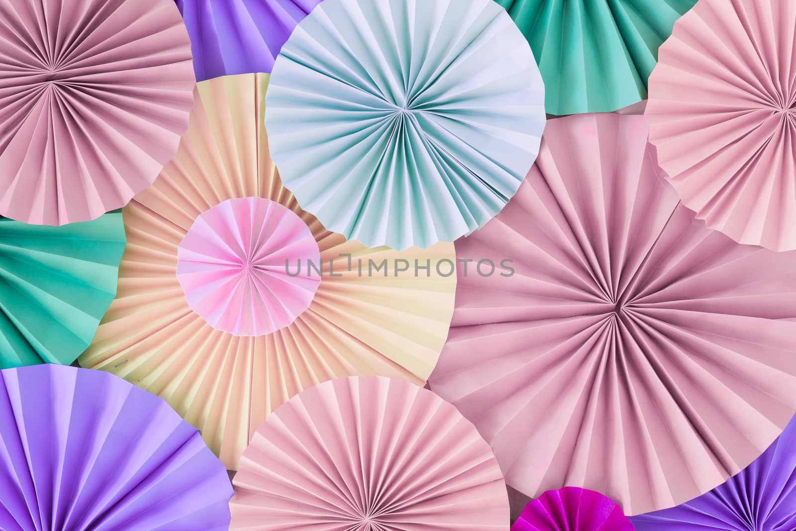 Romantic colorful celebration background wall with multicolored paper circles of pink, lilac, purple, green and beige colors