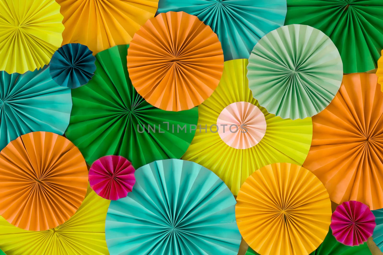 Colorful celebration background wall with multicolored paper circles of yellow, orange, green and blue colors