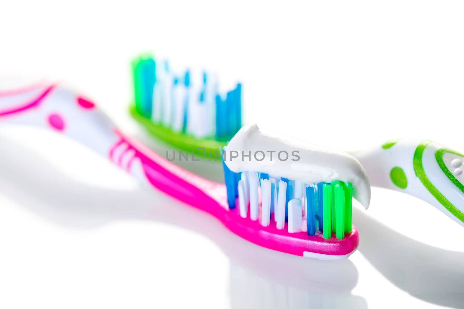 two toothbrushes closeup on against white background