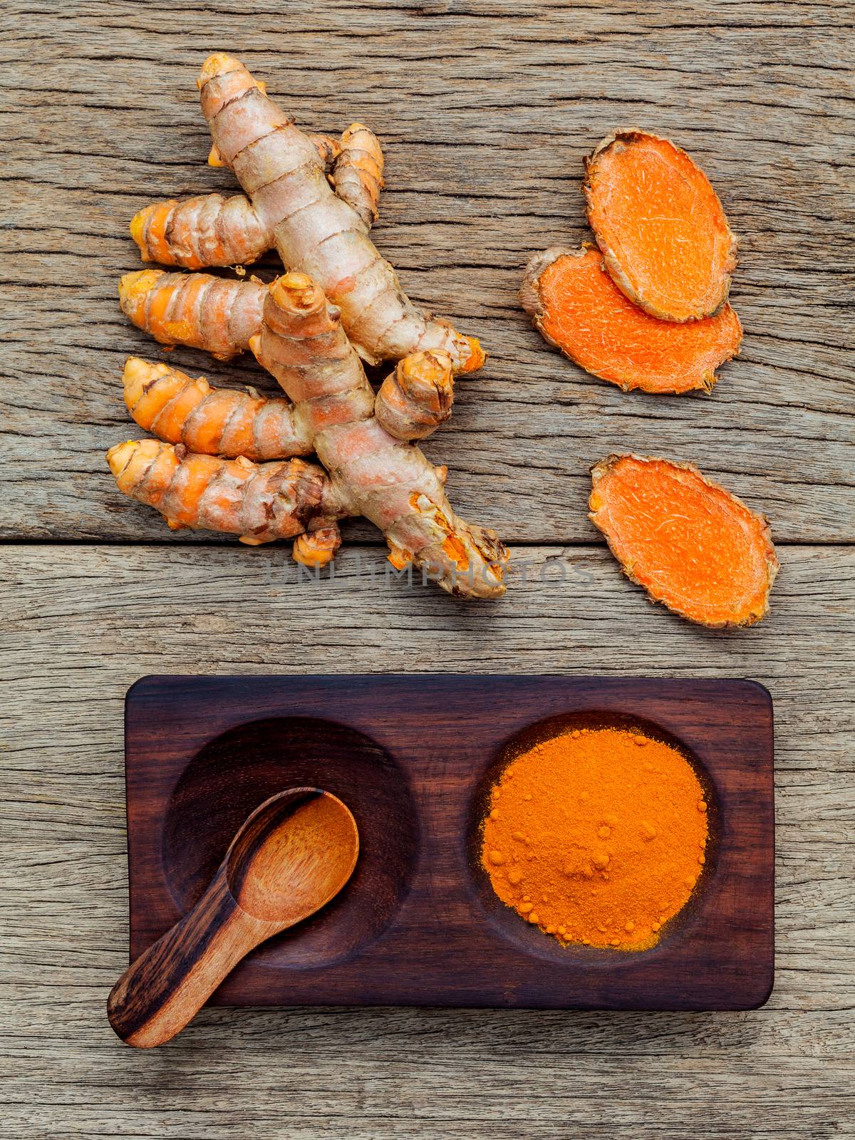 Alternative ingredients for skin care. Homemade scrub curcumin powder and curcumin roots set up on old wooden background.
