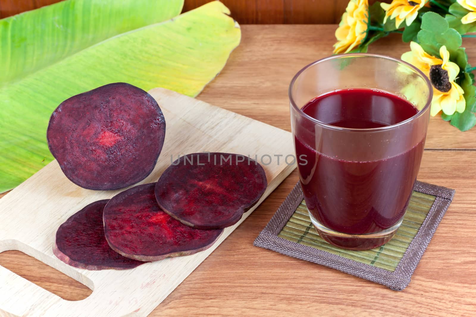 Fresh slices red beetroot and beetroot fruit juice in glass a wood background