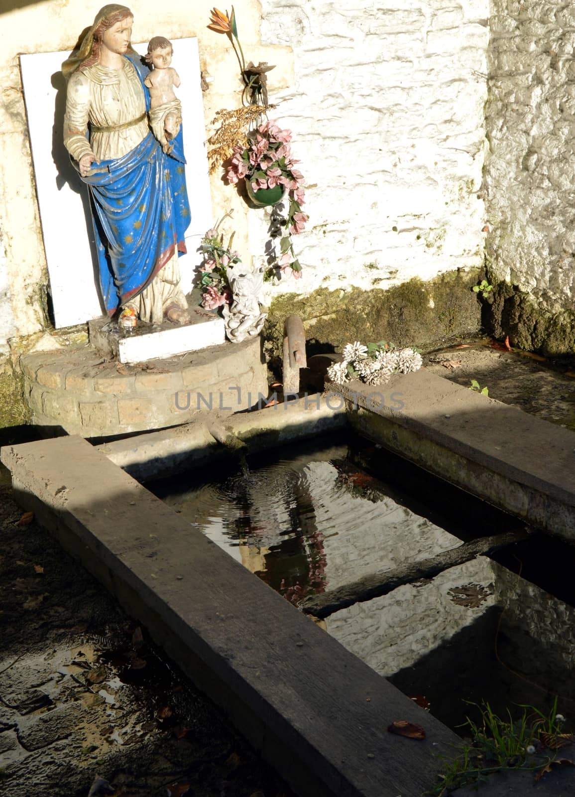 Virgin Mary and Child Jesus over an old water fountain with a laundry tub
