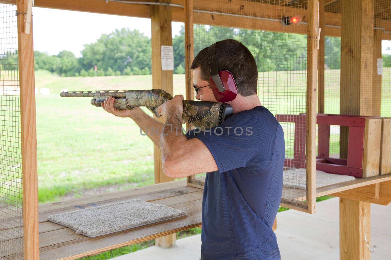 Young man sharpening his skills  with pump action type weapon at local rifle range