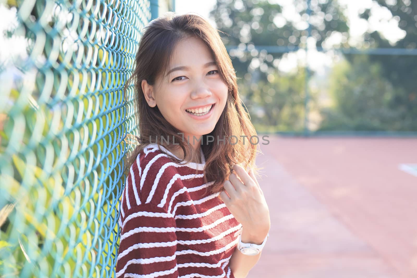 portrait of beautiful young woman toothy smiling with happy face with evening high light on hair use for happiness people and confident female 