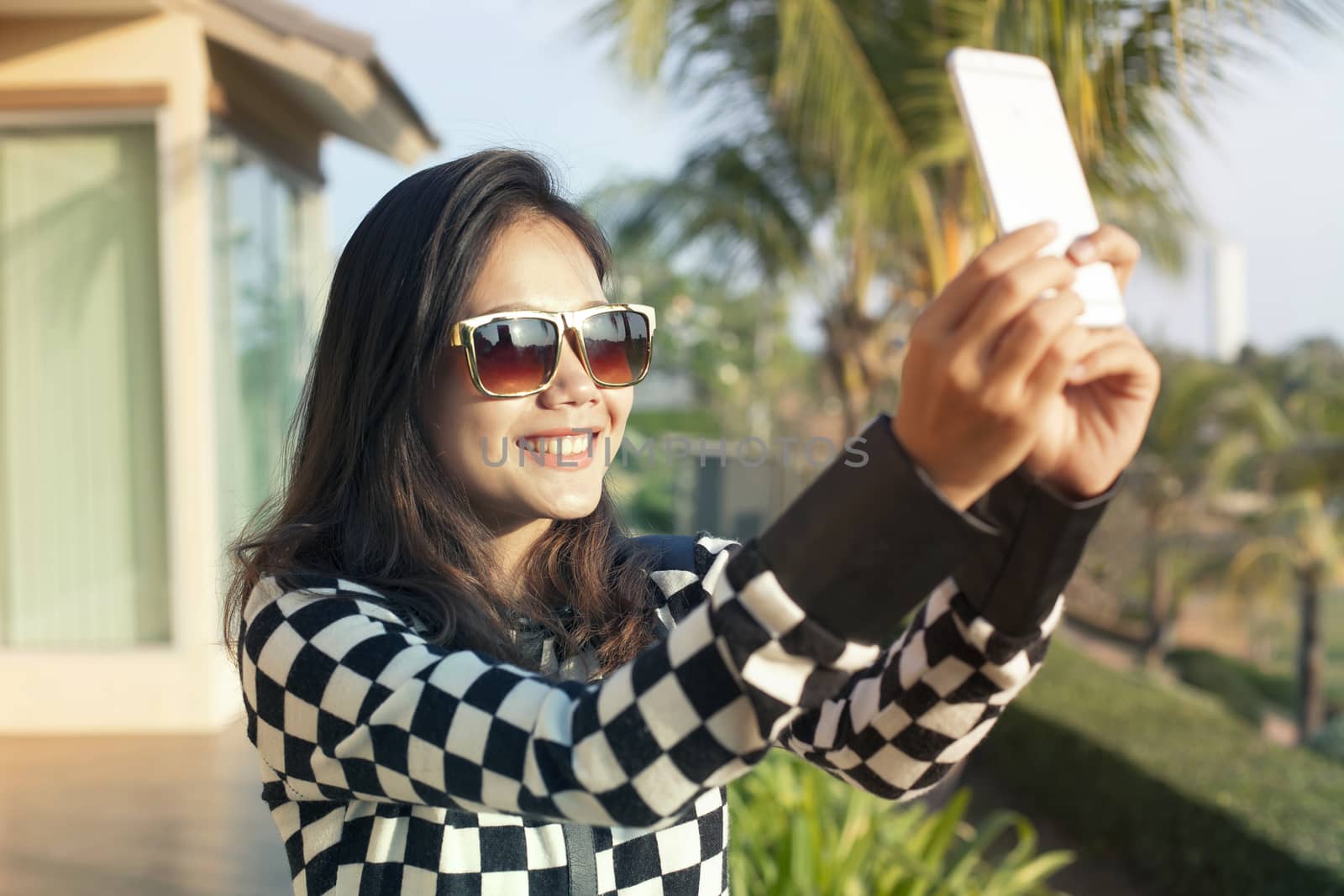 portrait of young beautiful woman wearing sun glasses take a photo ,selfie by mobile phone use for modern digital life and people activities