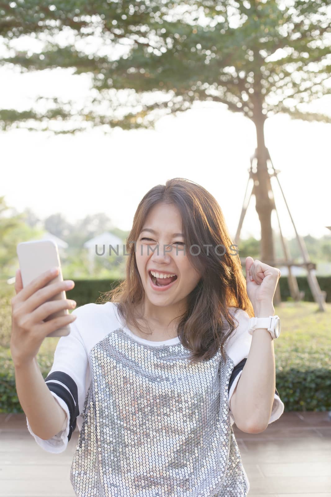 portrait of young woman watching to mobile phone screen with sur by khunaspix