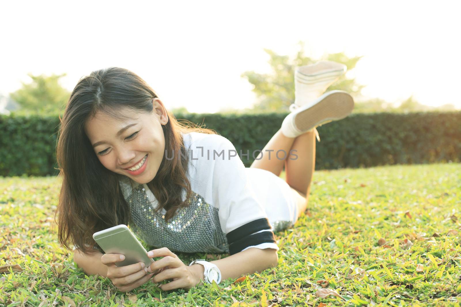 portrait of beautiful young woman lying and playing and watching by khunaspix