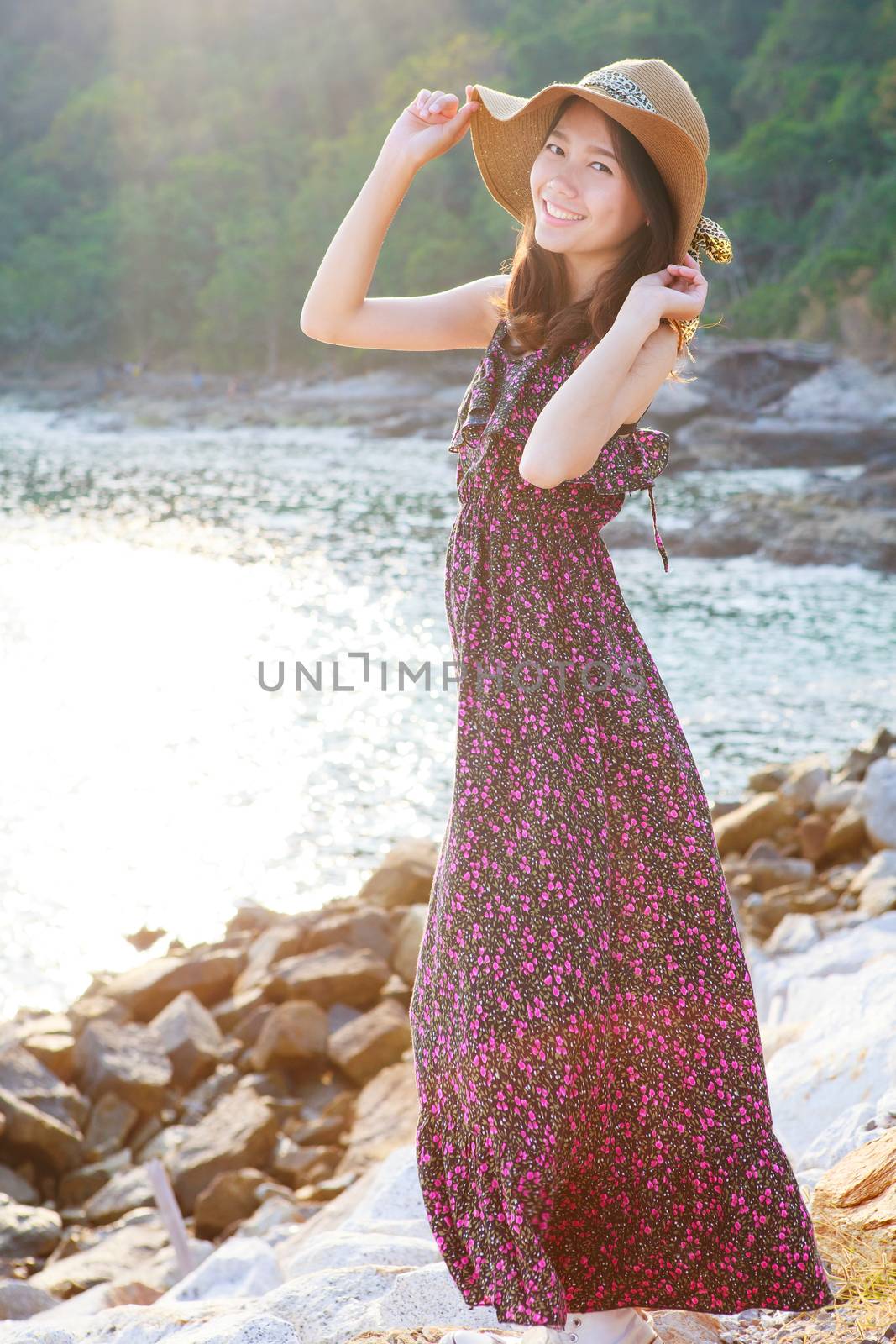 portrait of beautiful woman wearing straw hat and long dress standing beside sea beach smiling with happiness emotion use for people relax in vacation destination