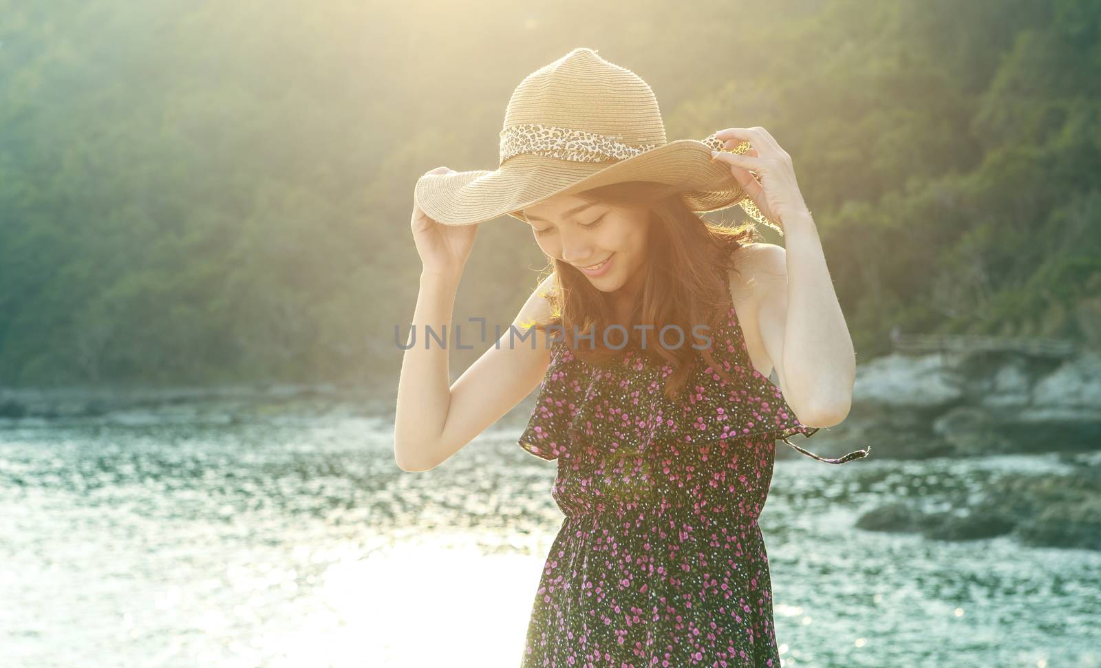 portrait of young beautiful woman wearing long dress and wide straw hat smiling at sea side location  use for modern life fashion and people activities on vacation