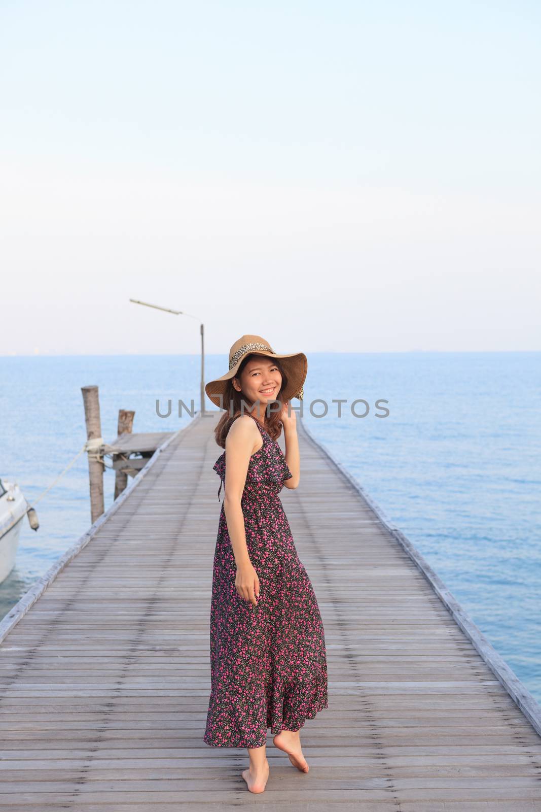 portrait beautiful woman wearing wide straw hat and long dress walking on wood bridge piers use for people relaxing and activities on holiday vacation 